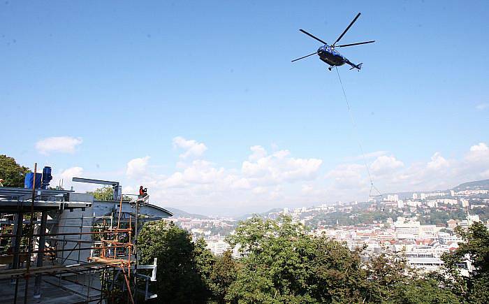 Vrtulník společnosti Aerocentrum při napínání montážního lana pro lanovku na Větruši.