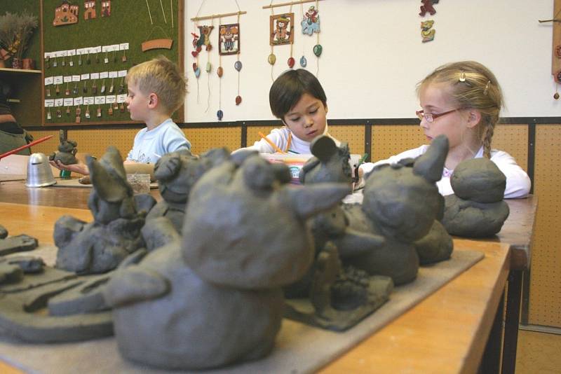 Děti vytvářejí v keramickém kroužku roztodivné figurky. 