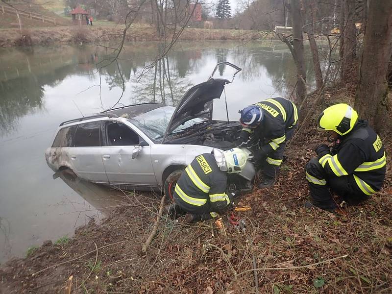 Hasiči auto, které skončilo až v rybníku, vytáhli na břeh a zajistili, aby uniklé provozní kapaliny neznečistily vodu.