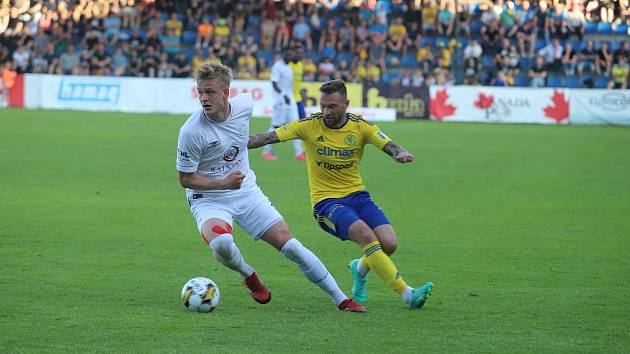 Fotbalista Zlína Antonín Fantiš (ve žlutém dresu) při zápase s Vyškovem nahání stopera Jaromíra Srubka