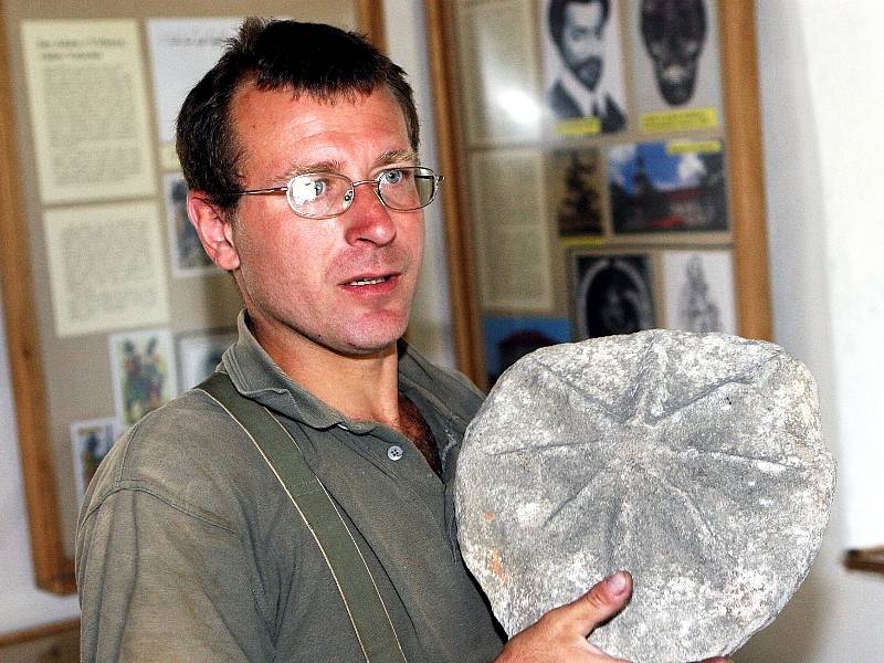 Kastelán David Juříček drží v rukou jeden z nejvzácnějších letošních archeologických nálezů na lukovském hradu, kamenný erb s osmicípou hvězdou rodu Šternberků. 