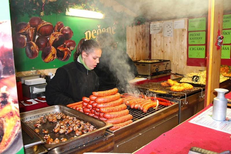 Stánkaři na Vánočním jarmarku ve Zlíně mají nelehkou práci. Mnozí se zahřívají, jak mohou.