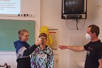 Lektor Skalička se dvěma dobrovolníky při pokusu s přenosným radiometrem, kterému se přezdívá "žehlička".