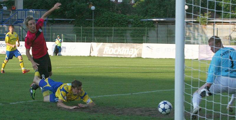 Druholigoví fotbalisté Tescomy Zlín podlehli ve 30. kole Znojmu. Brankář Znojma Vlastimil Hrubý nohou zasahuje proti hlavičce Tomáše Poznara.