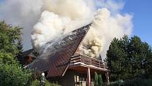 Rozsáhlý požár větší chaty v rekreační oblasti u Všeminy, při náročném zásahu se zranil jeden z hasičů.