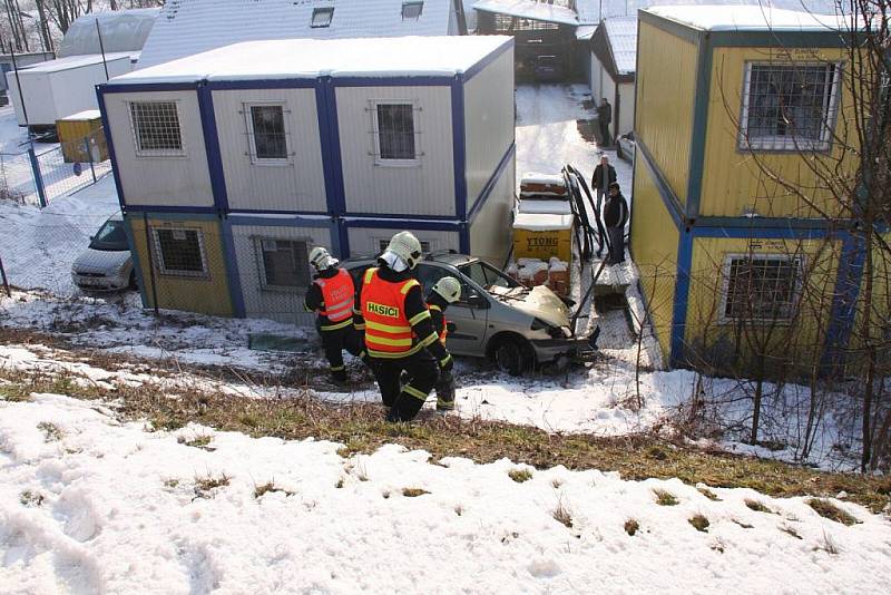 Řidič havaroval na namrzlé vozovce a skončil mimo komunikaci v hlubokém příkopu. Vrak auta se zastavil u ubytovacích jednotek průmyslového areálu.