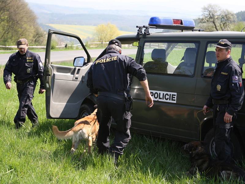 Policisté se psy prohledávají místo nálezu kostry člověka.