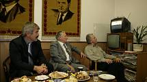 Komunisté sledují pod obrazy Lenina a Gottwalda v televizi průběh voleb.