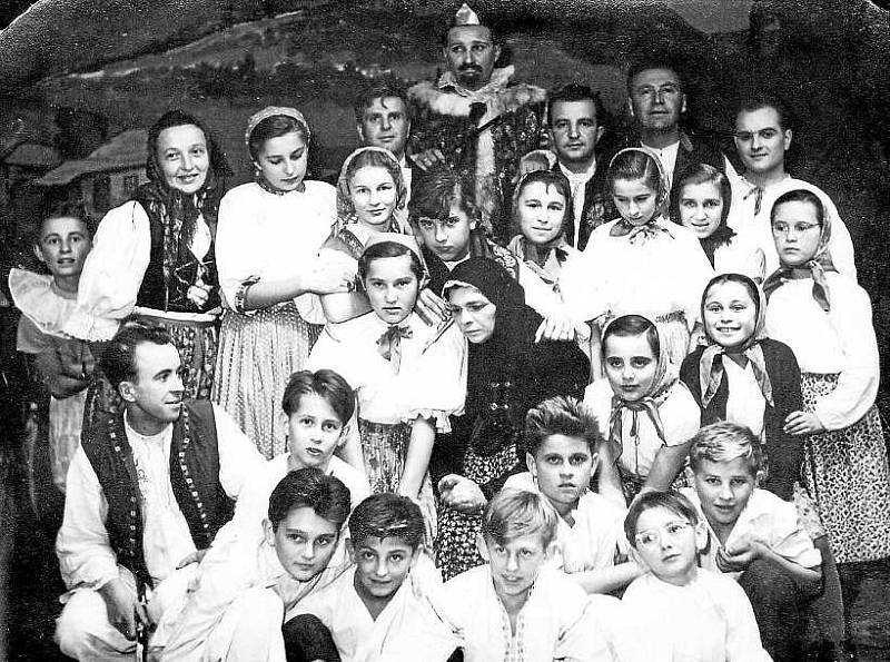 SLAVIČÍN, TRADIČNÍ MORAVSKÝ FOLKLOR. Na snímku přibližně z let 1955 – 1958 se usmívají děti z národopisného souboru Slavíček založeného r. 1953. Společnost jim dělají slavičínští herci i ochotnického divadla.