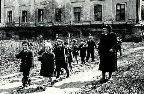 LUHAČOVICE, MALÍ POMOCNÍCI. Mateřská školka kolem roku 1955 sídlila v luhačovickém zámku. Děti s paní učitelkou vyrazily s nářadím do okolních zámeckých zahrad.
