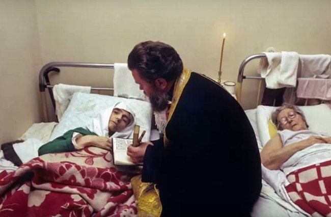 Ortodoxní kněz přišel dát poslední pomazání starým ženám umírajícím v hospicu.