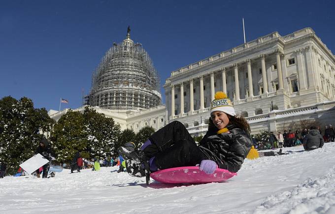 Alespoň někdo měl z přívalů sněhu radost! Dívka bobuje přímo před Capitolem!