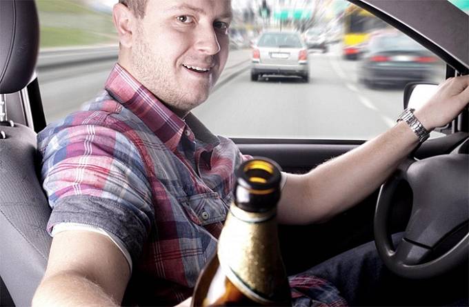 Muž vám podává alkohol, zatímco stojí křivě na dálnici