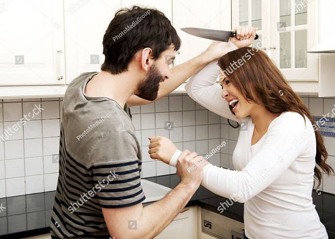Muž rozesmívá svou ženu, která ho chce rozbodat nožem