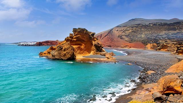 Průzračná voda Atlantického oceánu a rudé krajina jasně vystihují drsné Lanzarote, nejsevernější z Kanárských ostrovů.