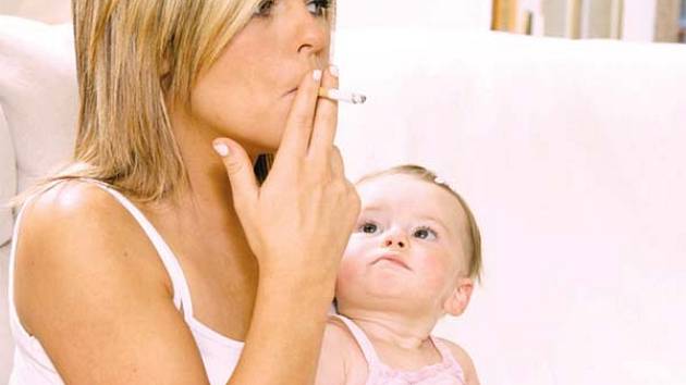 Hrozný pohled! Matka s cigaretou v ruce a dítětem v náručí.