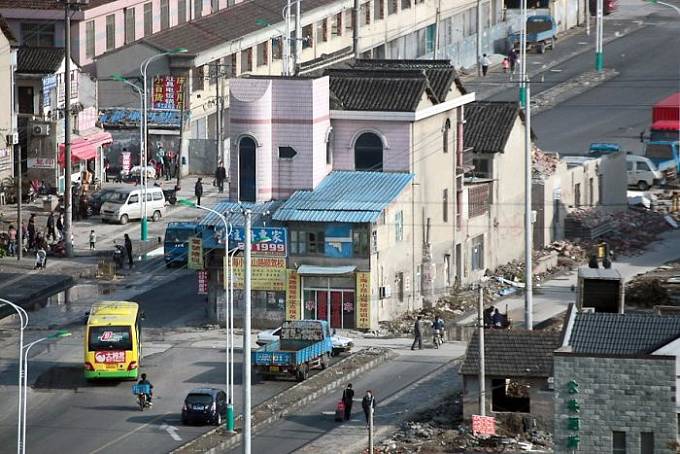 Komplex domů uprostřed silnice. Spoustu tvrdohlavosti.