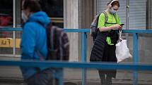 Žena s rouškou na zastávce MHD, 25. února 2021 v Ostravě. Kvůli koronavirové epidemii začala platit povinnost na frekventovaných místech nosit respirátor nebo dvě jednorázové zdravotnické roušky přes sebe.