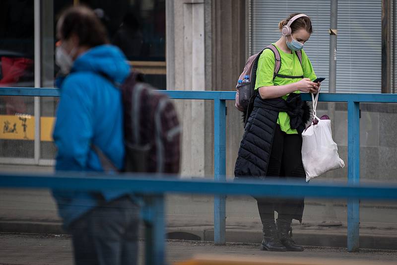 Žena s rouškou na zastávce MHD, 25. února 2021 v Ostravě. Kvůli koronavirové epidemii začala platit povinnost na frekventovaných místech nosit respirátor nebo dvě jednorázové zdravotnické roušky přes sebe.