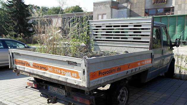 Odstavený pickup s porostem na korbě před kulturním domem Poklad v Ostravě-Porubě.