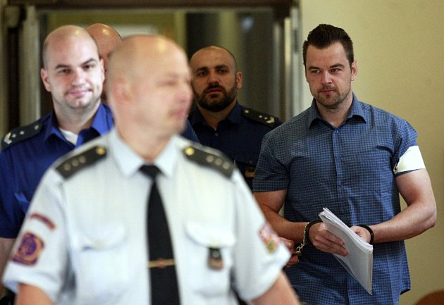 Petr Kramný v doprovodu eskorty na chodbě ostravského soudu.