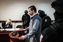Petr Kramný v jednací síni v doprovodu ozbrojené vězeňské eskorty.