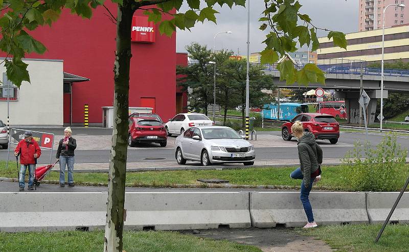 Plot bude stát u silnice mezi paneláky a nákupním střediskem.