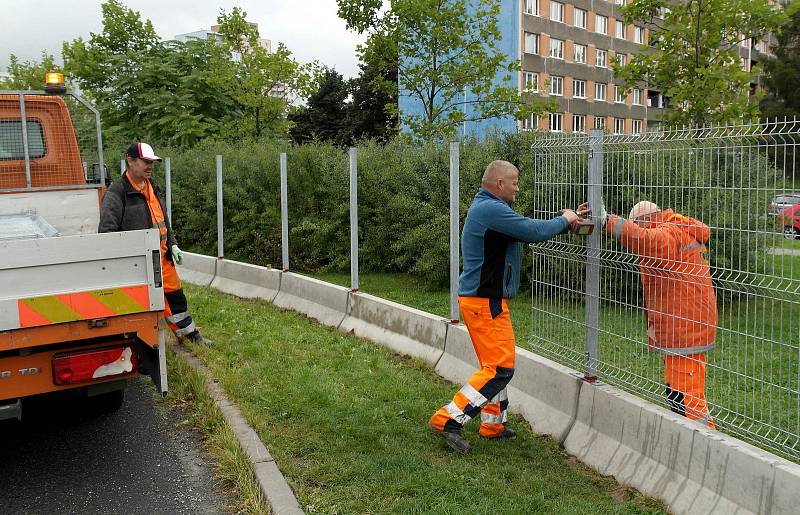 Plot bude stát u silnice mezi paneláky a nákupním střediskem.