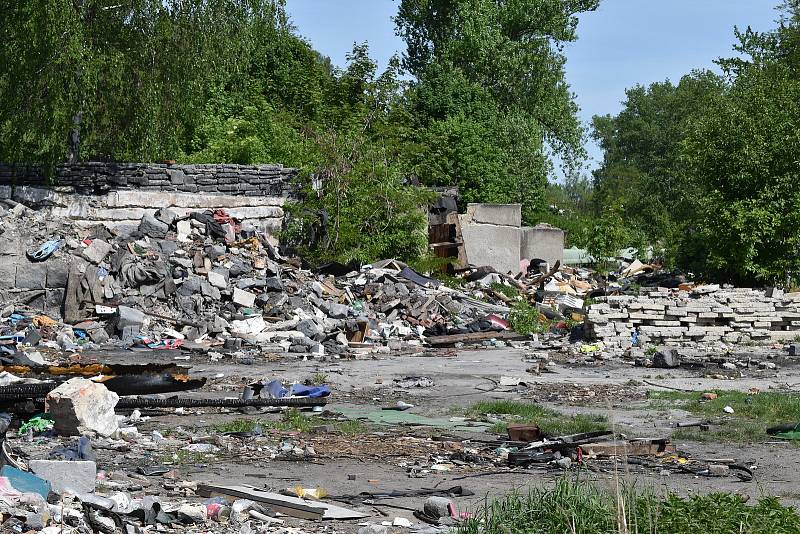 Garážový komplex u řeky Ostravice pod ulicí Muglinovskou, květen 2022. Odvézt bude nutné tuny odpadu.