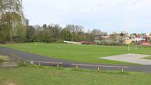 Sportovní areál v Pustkovci s fotbalovým hřištěm a atletickým oválem.