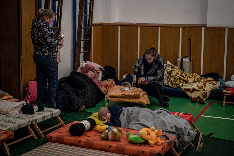 Lidé z Ukrajiny odpočívají ve sportovní hale místní základní školy po vstupu na Slovensko přes hraniční přechod Ubla ve slovenské Uble (Ubľa), 25. února 2022.