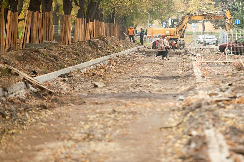 Staveniště. Místo chodníků se místní musí pohybovat po zemině, suti a kamení tvořící nerovnoměrný povrch. 