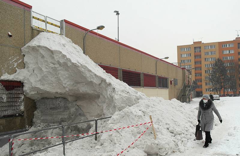 Hromada sněhu rostla a rostla z boku supermarketu mezi sídlišti Poruba a Svinov v západní Ostravě.