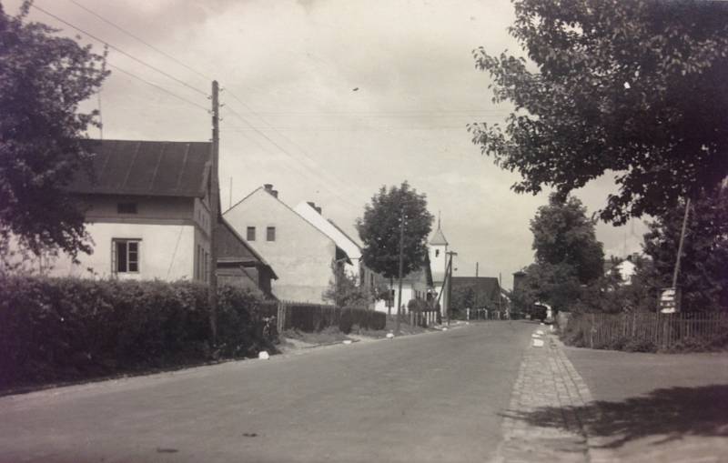 MITROVICKÁ. Takto vypadala Mitrovická ulice v Nové Bělé v roce 1937 ve směru od hostince pana Vantucha směrem ke Staré Bělé. V pozadí snímku vyčnívá věžička novobělské kapličky a část budovy obecního úřadu.