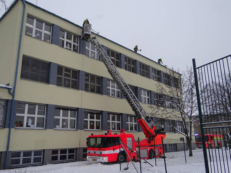 Odklízení sněhu ze střechy ZŠ Březinova v Ostravě-Hrabůvce.