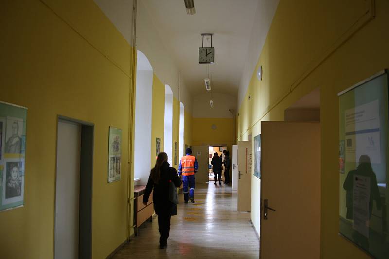 Volební místnosti na krnovském gymnáziu se buď otevřely o minutu dříve, nebo se hodiny na chodbě o minutu zpožďují.