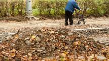 Staveniště. Místo chodníků se místní musí pohybovat po zemině, suti a kamení tvořící nerovnoměrný povrch. 