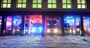 Záběr z videa zachycující světelnou vánoční show hasičských vozů.