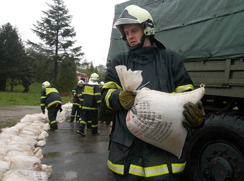 Desítky hasičů a vojáků budovaliv koblovské části Žabník hráz proti velké vodě