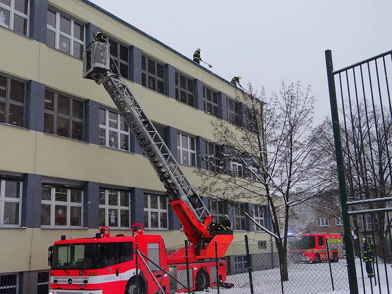 Odklízení sněhu ze střechy ZŠ Březinova v Ostravě-Hrabůvce.