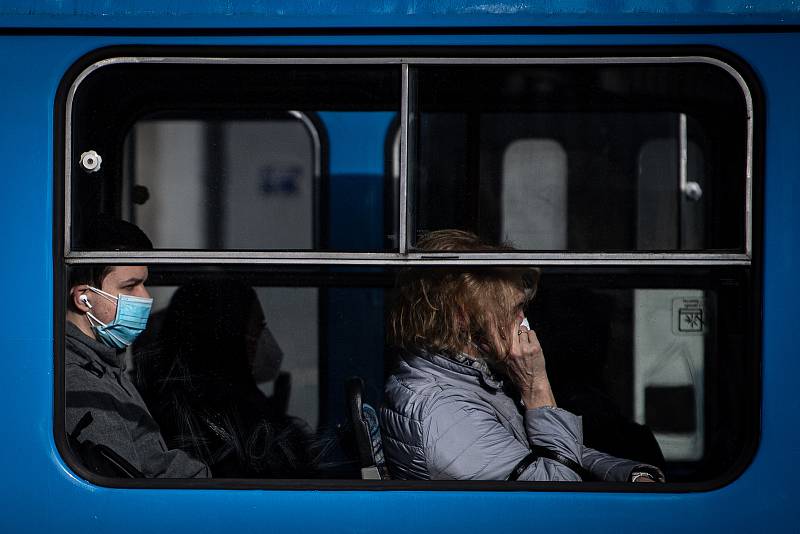 Muž s dvěma rouškami v tramvaji, 25. února 2021 v Ostravě. Kvůli koronavirové epidemii začala platit povinnost na frekventovaných místech nosit respirátor nebo dvě jednorázové zdravotnické roušky přes sebe.