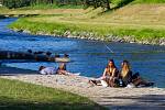 Lidé užívající si teplé počasí v Komenského sadech u řeky Ostravice v centru Ostravy.