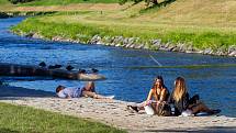 Lidé užívající si teplé počasí v Komenského sadech u řeky Ostravice v centru Ostravy.