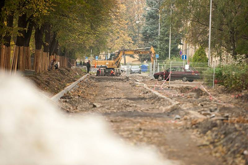 Staveniště. Místo chodníků se místní musí pohybovat po zemině, suti a kamení tvořící nerovnoměrný povrch. 