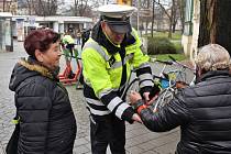 Policisté během preventivních akcí rozdávají reflexní pásky.