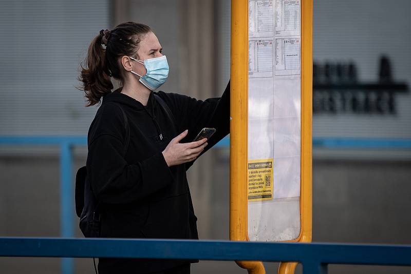 Žena s dvěma rouškami na zastávce MHD, 25. února 2021 v Ostravě. Kvůli koronavirové epidemii začala platit povinnost na frekventovaných místech nosit respirátor nebo dvě jednorázové zdravotnické roušky přes sebe.