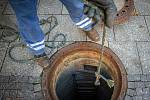 Pracovníci společnosti Ostravské vodárny a kanalizace (OVAK) pří deratizaci kanalizace, 22. října 2021 V Ostravě. Měřidlem si zjišťuje přítomnost metanu v kanalizaci.
