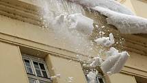 Hasiči v pondělí po poledni shazovali hromady sněhu ze střechy domu v ostravské Nádražní ulici.