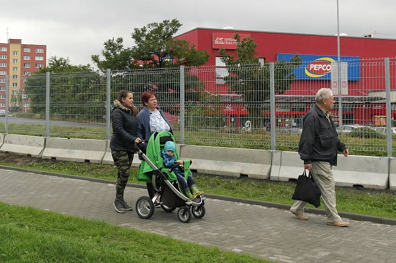 Plot bude stát u silnice mezi paneláky a nákupním střediskem.