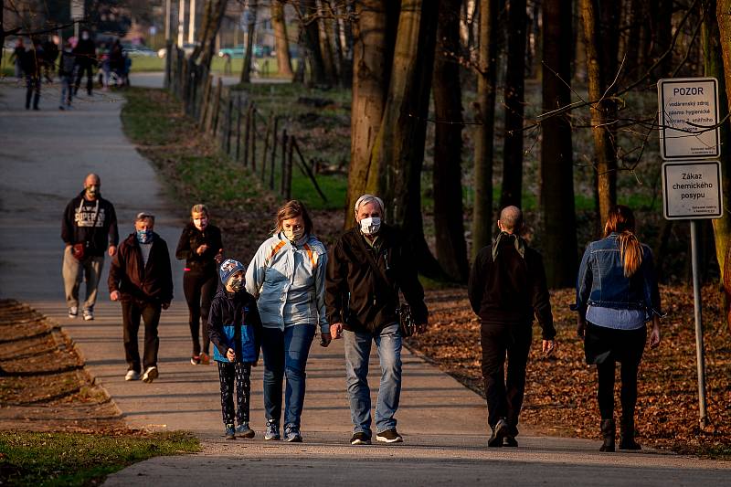 Lidé v rouškách na procházce v Bělském lese v Ostravě, 28. března 2020